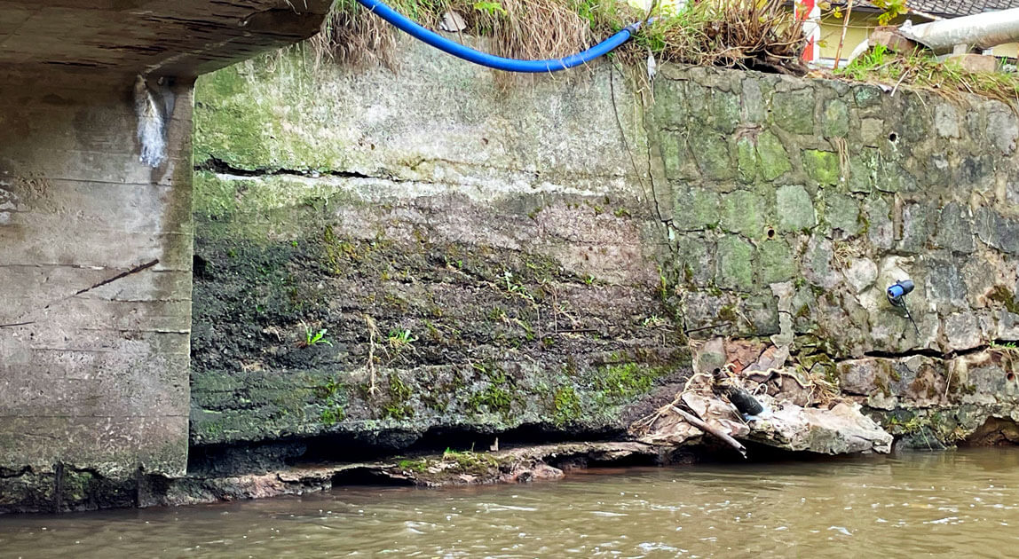 Widok muru oporowego w obrębie przyczółka obiektu mostowego, widoczne poziome spękanie muru o dużej rozwartości