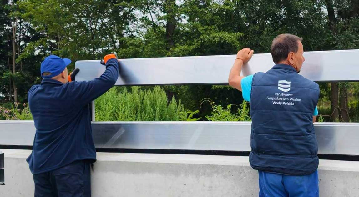 Pracownicy montują mobilną zaporę przeciwpowodziową podczas prób w Brzegu Dolnym.