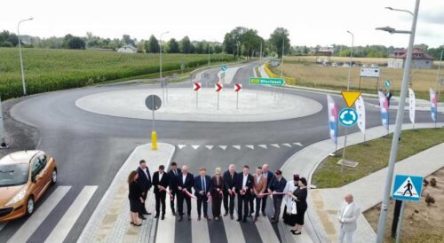 Uczestnicy uroczystego otwarcia ronda w Dyblinie stoją na przejściu dla pieszych przed nowym rondem.