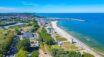 Widok z lotu ptaka na nadmorską miejscowość, plażę i port. Zdjęcie ilustracyjne.