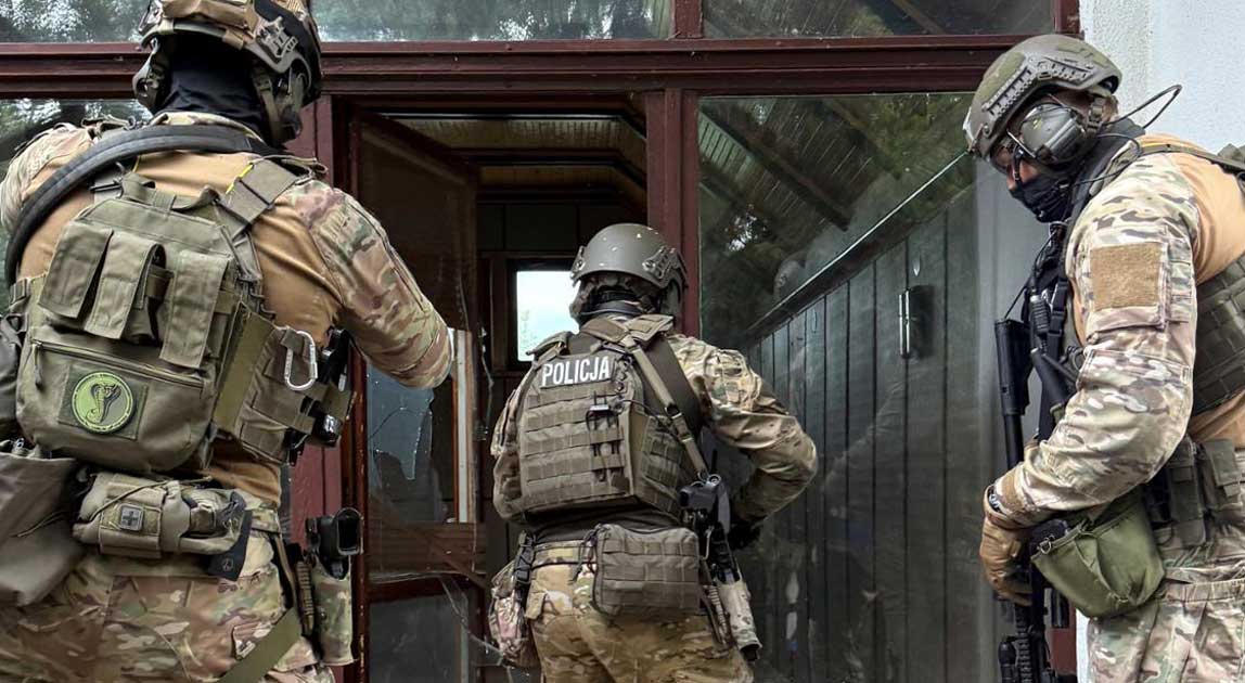 Funkcjonariusze Samodzielnego Pododdziału Kontrterrorystycznego Policji podczas ćwiczeń przy wejściu do budynku.