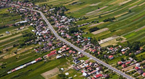 Widok z lotu ptaka na drogę krajową DK84 przebiegającą przez miejscowość przewidzianą do rozbudowy.