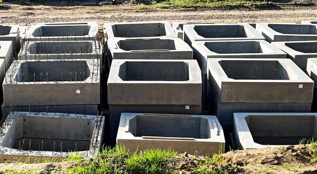 Widok segmentów prefabrykowanych o przekroju skrzynkowym przygotowanych do montażu na płycie fundamentowej