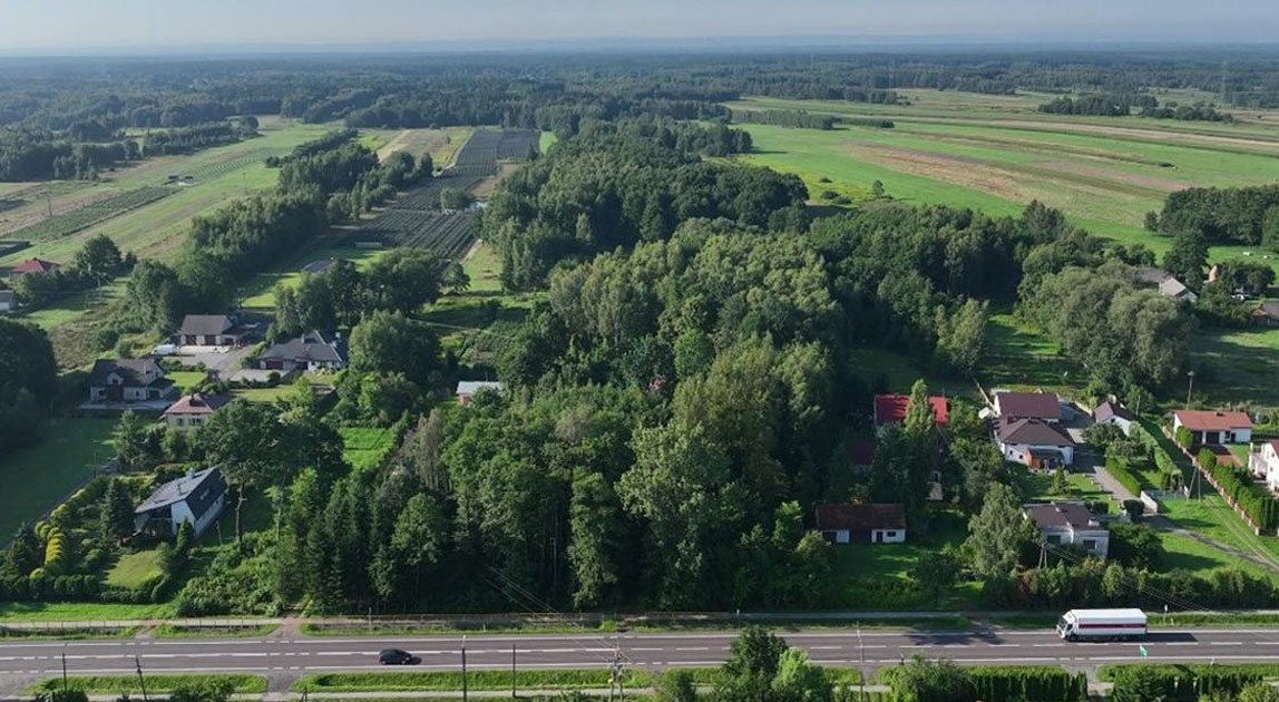 Widok z lotu ptaka na DK9 przebiegającą przez tereny rolne i rozproszoną zabudowę
