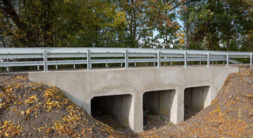 Wyremontowany betonowy przepust pod drogą wojewódzką nr 573 zabezpieczony barierami drogowymi
