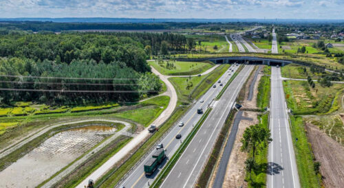 Widok z lotu ptaka na dwujezdniową drogę ekspresową S19, wiadukt i zbiornik retencyjny
