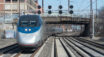 Pociąg pasażerski jadący wielotorową zelektryfikowaną linią kolejową